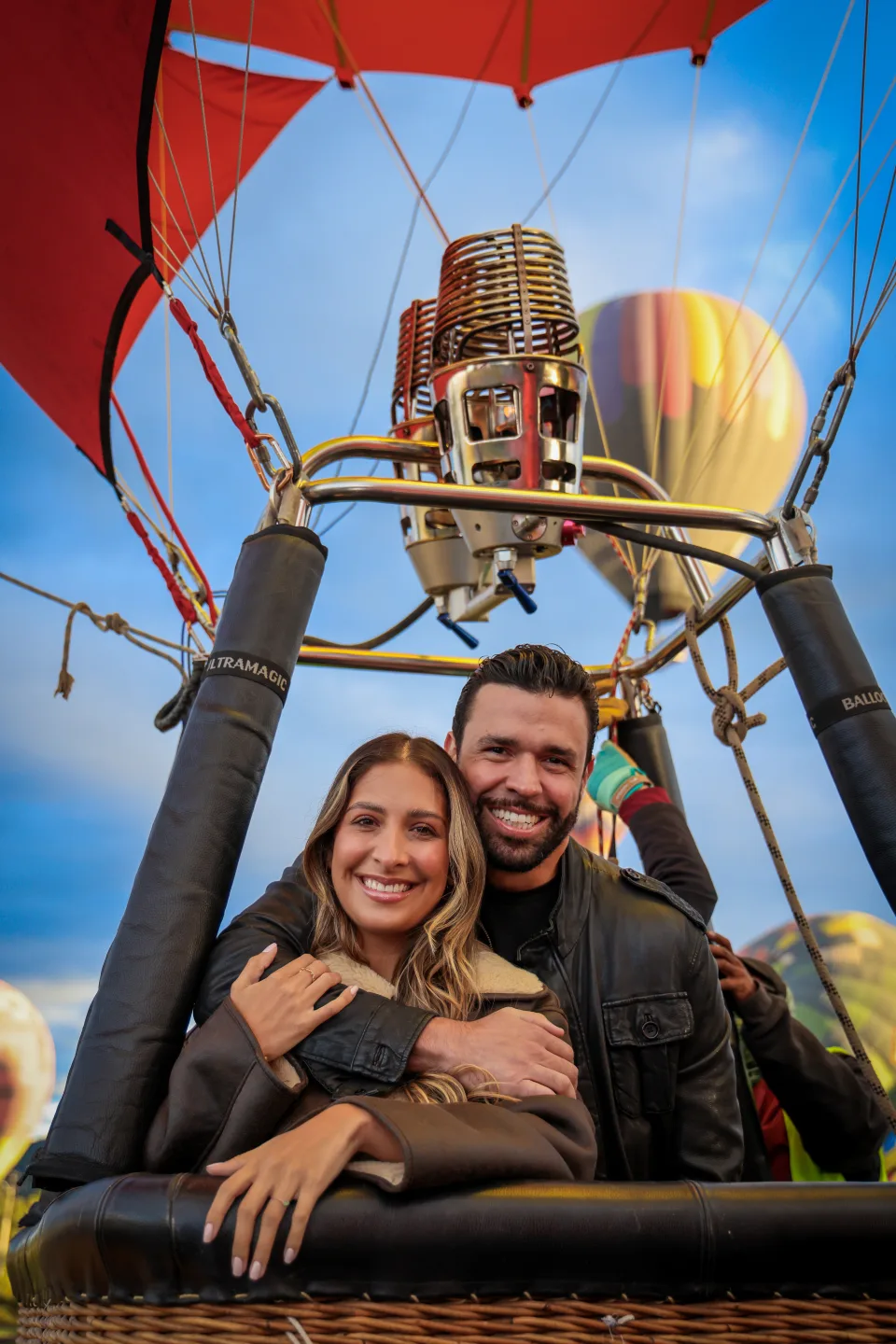 Couple embracing inside a hot air balloon basket at sunrise over Teotihuacan