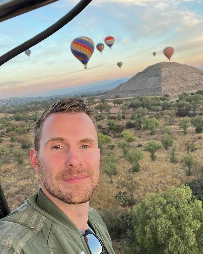 Passenger enjoying the view of the Teotihuacan pyramids from a hot air balloon